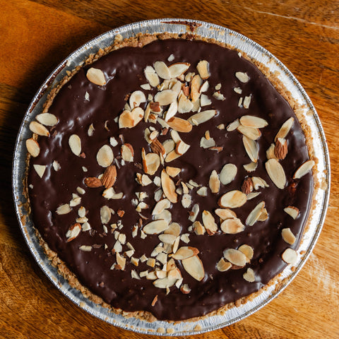 Chocolate pie with nuts on a wooden board