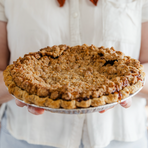 Person holding a pie with a crumbly crust